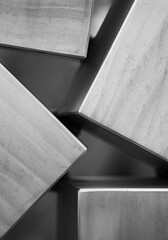 black and white close up of the corners of four metal squares or boxes close to each other but not...