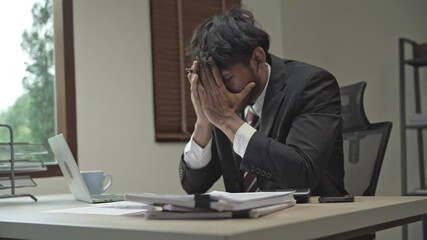 Burnout concept. Asian Business man touching forehead having headache boring job and tired emotional pain and professional person depressed over risk