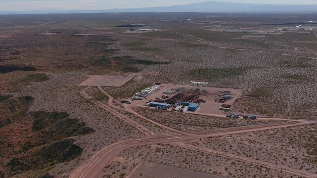 A drone shows the plateau and flies over the fracking field in Vaca Muerta, Neuqu&eacute;n. Red and blue trucks can be seen. The Auca Mahuida Volcano can be seen in the distance.
