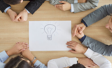 Business team people at desk, light bulb bright lamp drawing of new idea, diverse work group engaged in teambuilding, planning corporate success, teamwork, entrepreneurs seek to develop start up