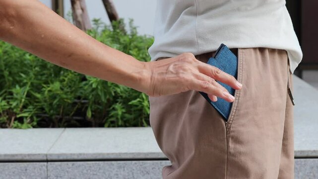 Old man about to be pickpocketed, leaving wallet unattended and easy to steal, concept Image of Urban crime, pick pocketing, petty criminal, caution beware of pickpocketeer