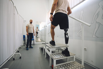 Rehabilitation specialist assists to amputee veteran