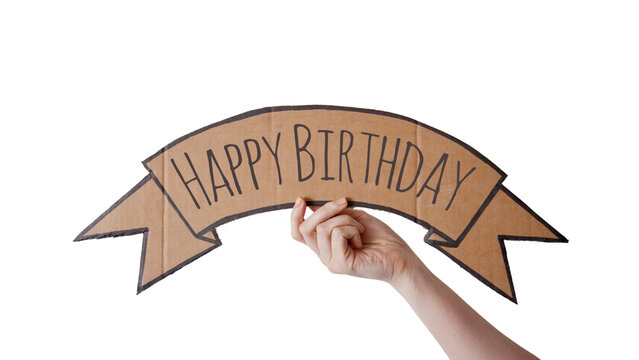 A cardboard banner with the text "HAPPY BIRTHDAY" is being held up by a hand,  isolated on white, transparent background	
