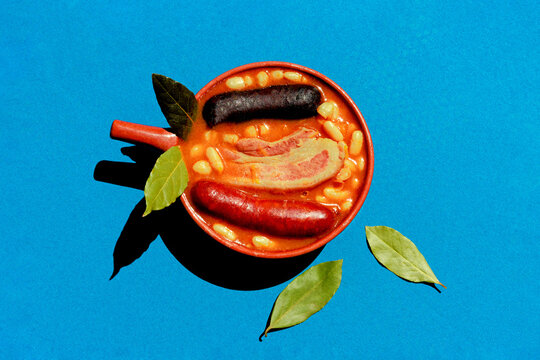 Asturian fabada with chorizo and blood sausage on a blue background
