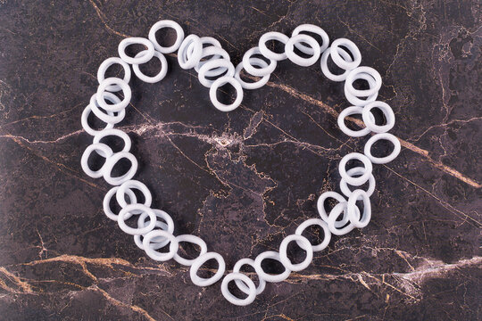 A heart made of white hair bands laid out on a dark background. Space for the text.