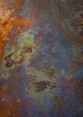 abstract background backdrop or wallpaper of oxidized metal with shapes and patterns of rust color green grey purple orange and blue grunge colors with an atmospheric look vertical image room for type