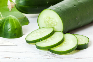 Cucumbers with slices on rustic table closeup
