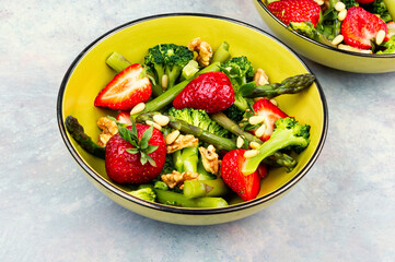 Vegan salad of green asparagus, strawberries.