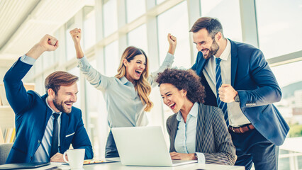 Fototapeta premium A group of people are celebrating a victory in a business meeting