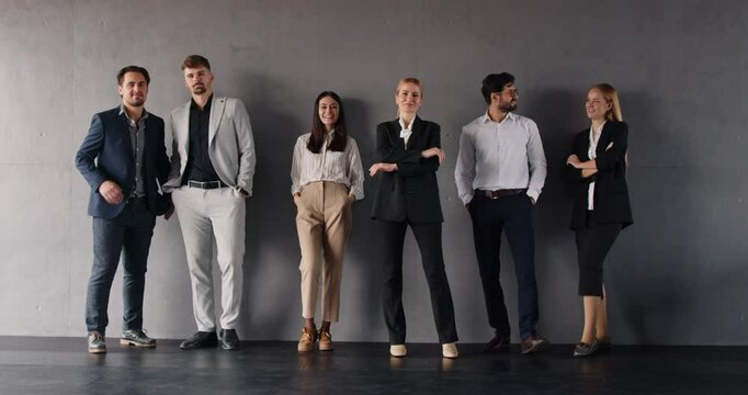 Professional business people team, standing in row near grey wall looking at camera, smiling diverse human resource corporate employees, motivated staff coworkers group, hr team company portrait 