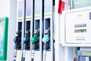 Fuel pumps at a gas station during daylight hours in a busy urban area © Alina