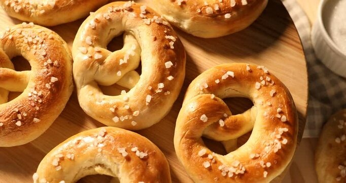 Tasty salted pretzels on table, rotating. Top view