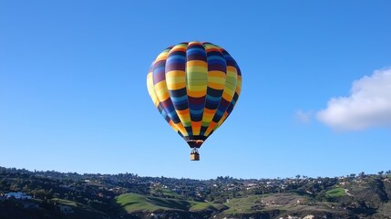 Obraz premium A hot air balloon ascending above rolling hills, reflecting dreams taking flight