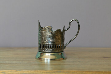 Russian traditional tea glass holder on a wooden table on a grey background