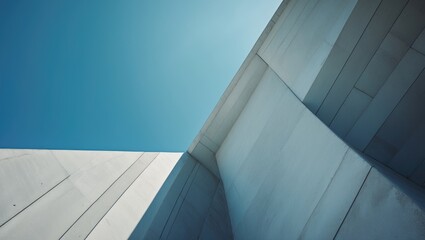 Contemporary Urban Structure Featuring Abstract Roof Angles and Concrete Walls with Geometric Triangle Designs Beneath a Blue Sky