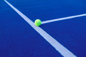padel ball on a blue padel court near the line