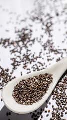 organic chia seeds on a white background, helping to maintain balance in the body and improve the absorption of nutrients. concept of health, nutrition, wellness.
