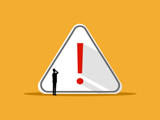 Alert and caution concept, businessman at warning sign.