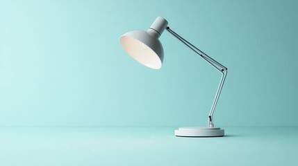 Modern white desk lamp on an aqua background, creating a calm and minimalistic atmosphere.
