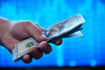 Hands holding and counting dollar banknotes