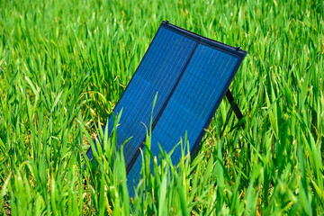 Portable solar panel standing in green grass field