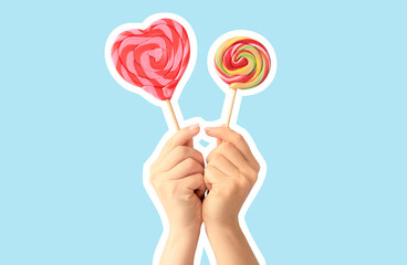 Hands with sweet lollipops on color background