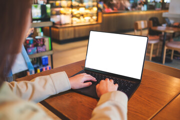 Mockup image of a woman typing on laptop computer with blank white desktop screen in cafe