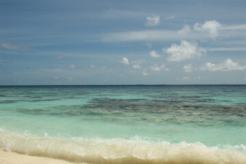 Tranquil ocean view with clear water and blue skies on a sunny day in the Maldives 