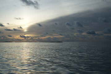 Fototapeta premium Tranquil sunset over calm ocean with dramatic clouds in the Maldives 