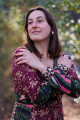 Close-up. portrait of a beautiful smiling girl in a dress and accessories. Beautiful model in the forest.