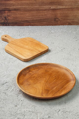 Empty Wooden Plate and Cutting Board on Concrete Table with Wooden Wall Background, Minimalist Kitchenware Flatlay for Food Mockup, Rustic Natural Cooking Scene with Copy Space