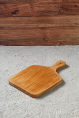Empty Wooden Cutting Board on Concrete Table with Rustic Wooden Wall Background, Minimalist Kitchenware Scene, Food Preparation Surface with Copy Space for Culinary Design or Product Display