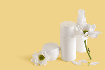 Cosmetic products and chamomile flowers on color background
