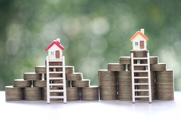 Mortgage,Model house and stack of coins money on natural green background,Business investment and real estate concept
