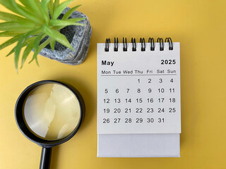 2025 May desk calendar flat lay on yellow background 