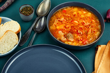 Bowl of red borscht with meat.