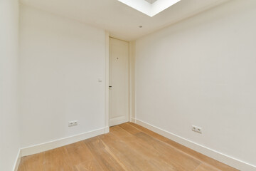 A simple, minimalistic interior space showcasing clean lines, a warm wooden floor, and soft white walls, ideal for modern living or office use.