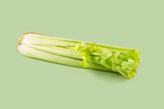 Fresh celery stalks resting on a green background