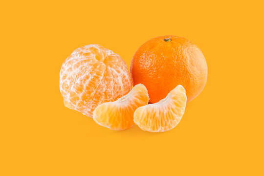 Peeled and whole mandarin with segments on orange background