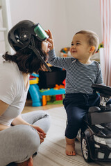 Mother and her two year old son playing in a children room, symbolizing motherhood and care