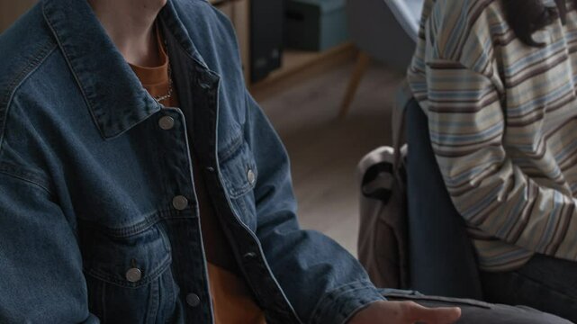 Slowmo tilt up shot of teen boy in VR headset touching spider confronting phobia during group therapy in classroom