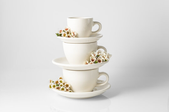 Elegant white cups and saucers with spring flowers