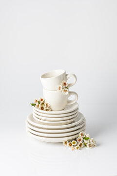 Elegant white cups and plates set with spring flowers