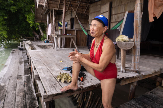 Elderly Asian female tourist relaxing on Kri Island, Indonesia