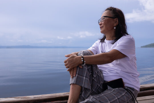 Mature woman gazing at the sea from a homestay on Kri Island