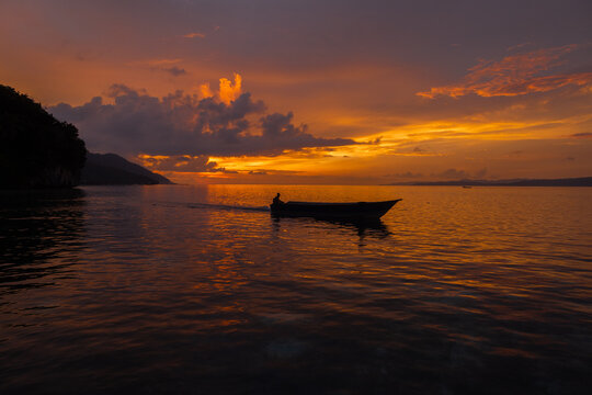Sunset view with silhouette of a boat at Kri Island, Raja Ampat