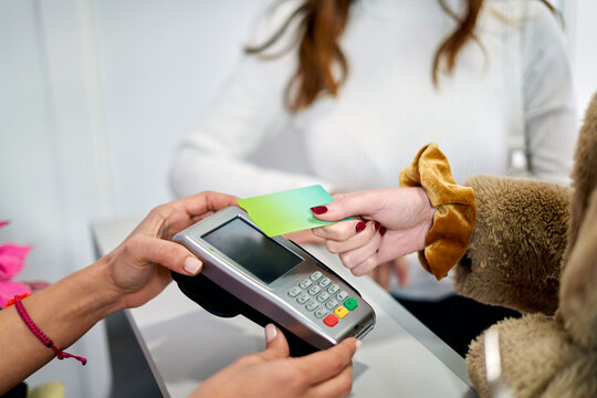 Customer Making Contactless Payment at Beauty Salon Counter - Powered by Adobe