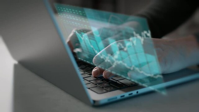 Hands typing on laptop with digital screen overlay of the stock market