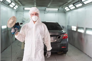 Car polishing. Vehicle polishing and detailing service in car workshop. Mechanic prepares using...