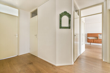 Elegant and spacious interior hallway featuring light wood flooring, sleek doors, and stylish decor that enhances a contemporary living space.